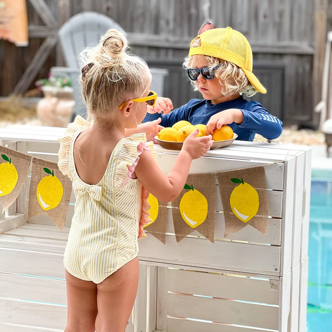 RuffleButts Girls Seersucker One Piece with Roshambo Yellow Sunglasses